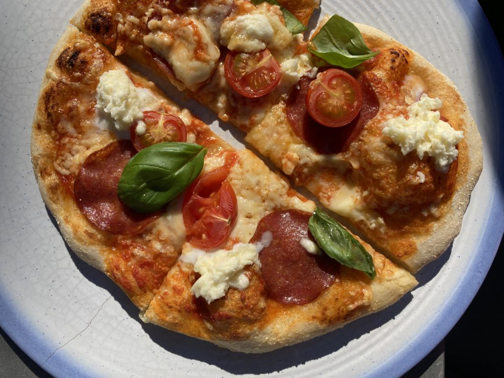 Leckere Pizza mit Salami, Kirschtomaten, Mozzarella und Basilikum